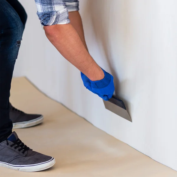Profissional realizando reparo rápido em parede de gesso em apartamento de Curitiba